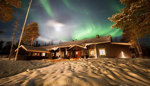 Nellim Wilderness Hotel main building with northern lights above it