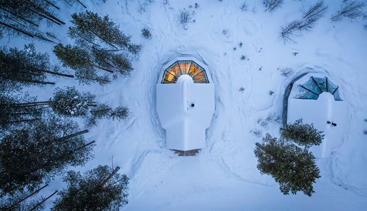 Aerial view of an aurora cabin in the snowy wilderness at Aurora Village in Finnish Lapland