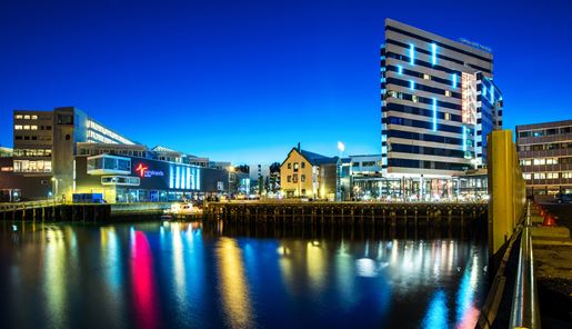 The facade of the striking Clarion Hotel the Edge next to the glistening water in Tromso in Norway.