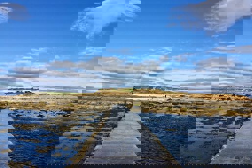 View across the causeway to the Brough of Brisay, accessible at low tide on Orkney in Scotland.